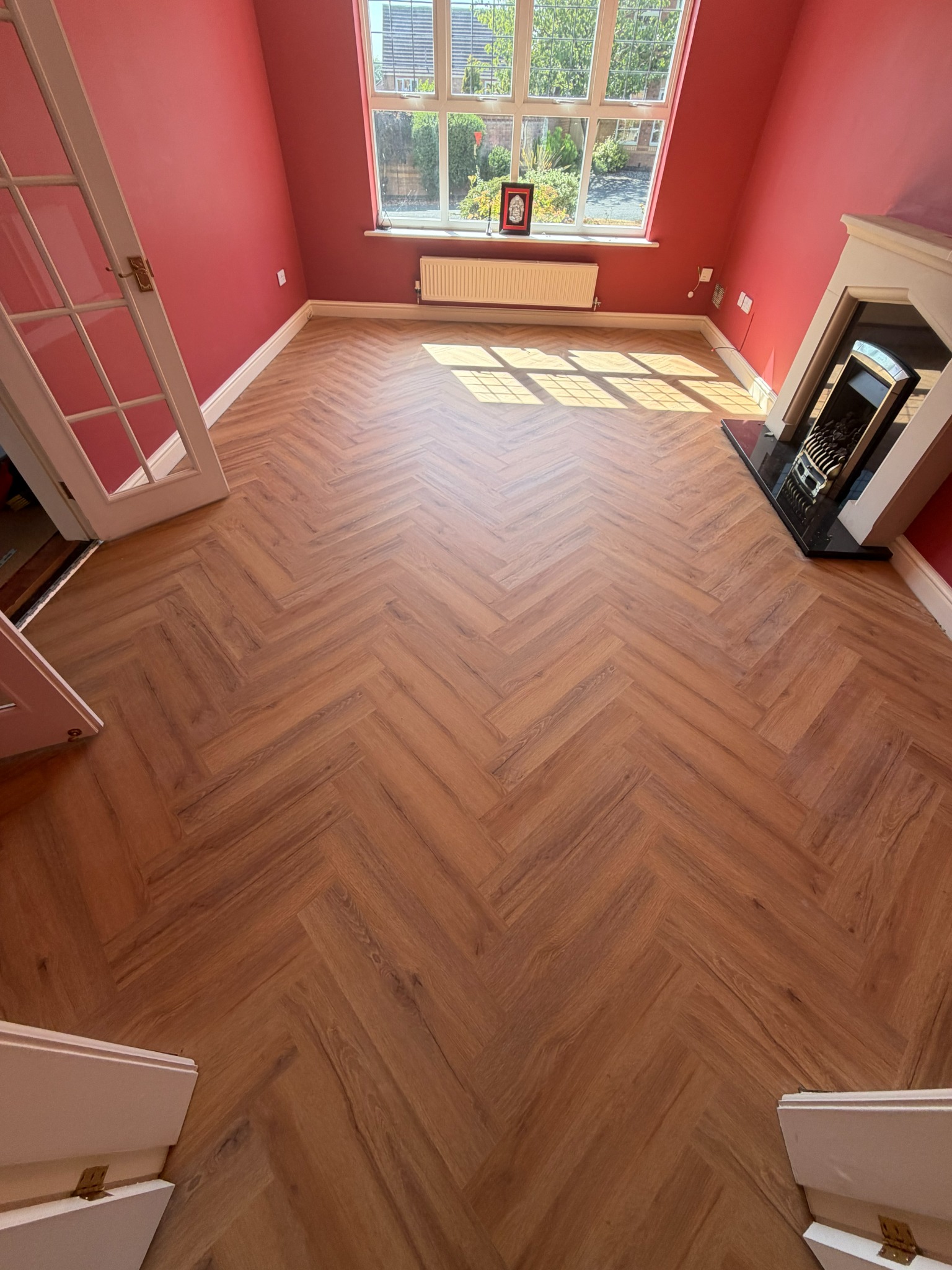 Herringbone LVT click flooring in a red room