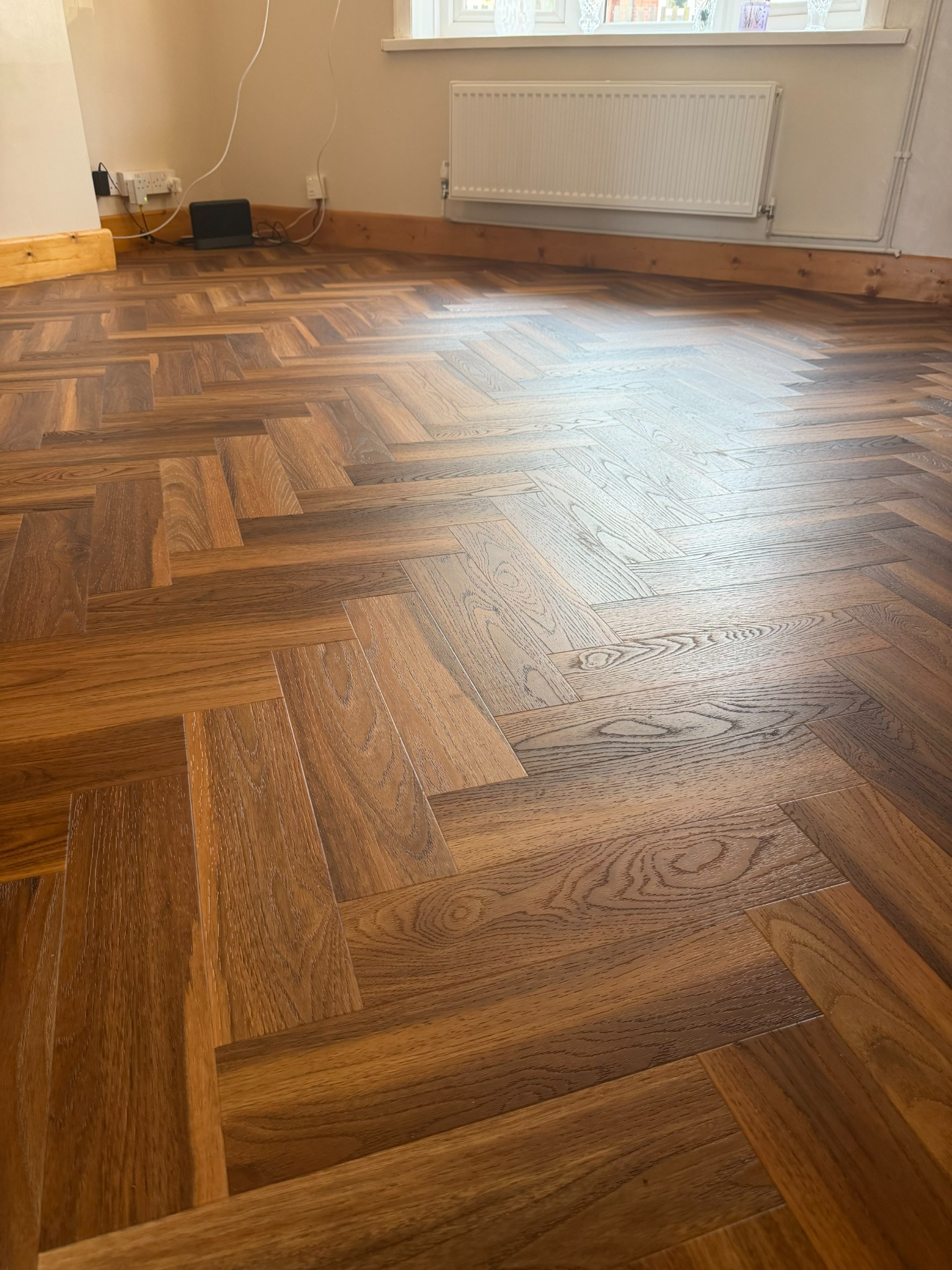 Warm walnut herringbone flooring fitted by True Form Flooring